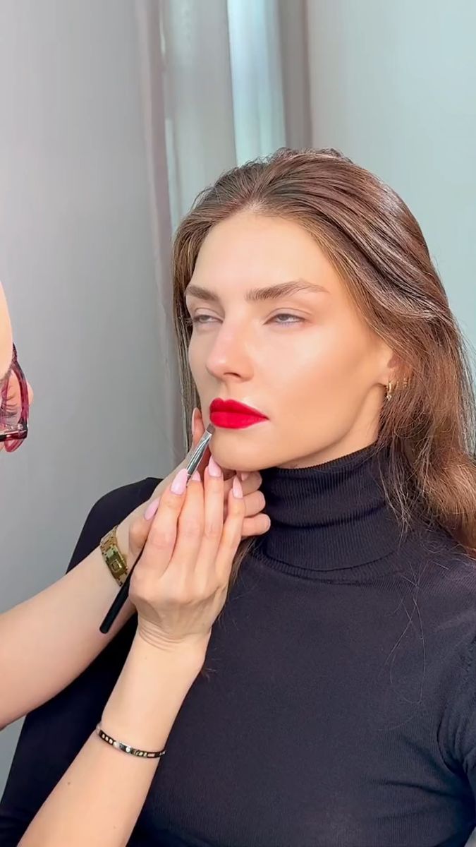 Make-up artist applying a red lip on set, Waterproof beauty editorial