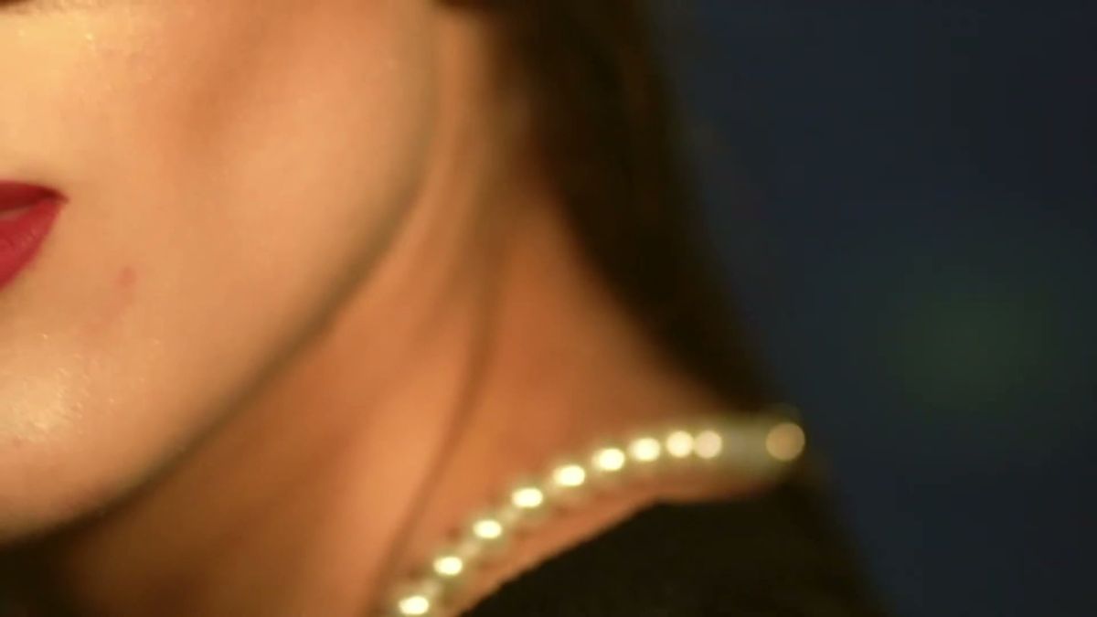 Close-up of a pearl necklace and red lip at night