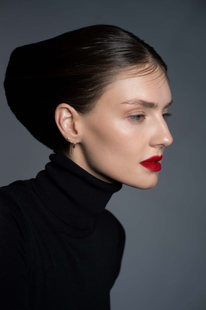 Side-lit beauty portrait with a red lip, skin texture kept
